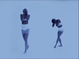 Video still of two people in white undergarments 