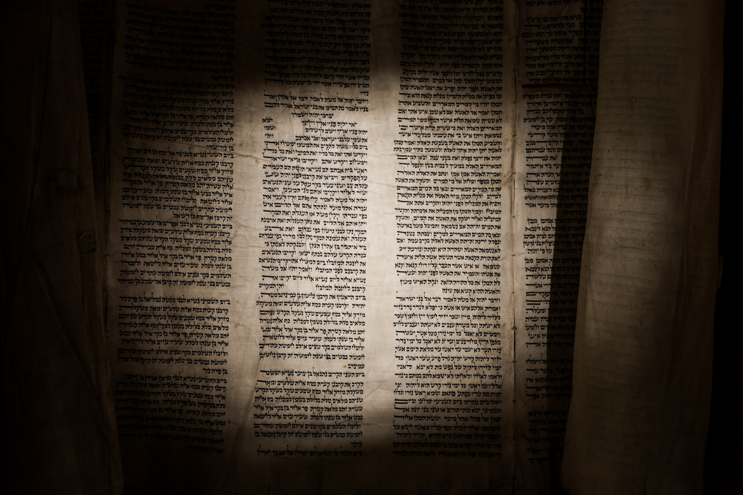 Torah scroll opened to the priestly blessing shot with artistic lighting.