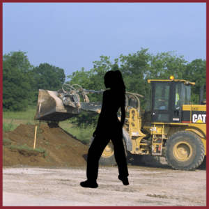 silhouette of a young woman in front of a construction site with a bulldozer