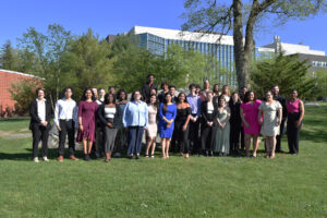 This is a picture of a group of people at the Student Leadership Awards outside on grass with a tree in the background. 