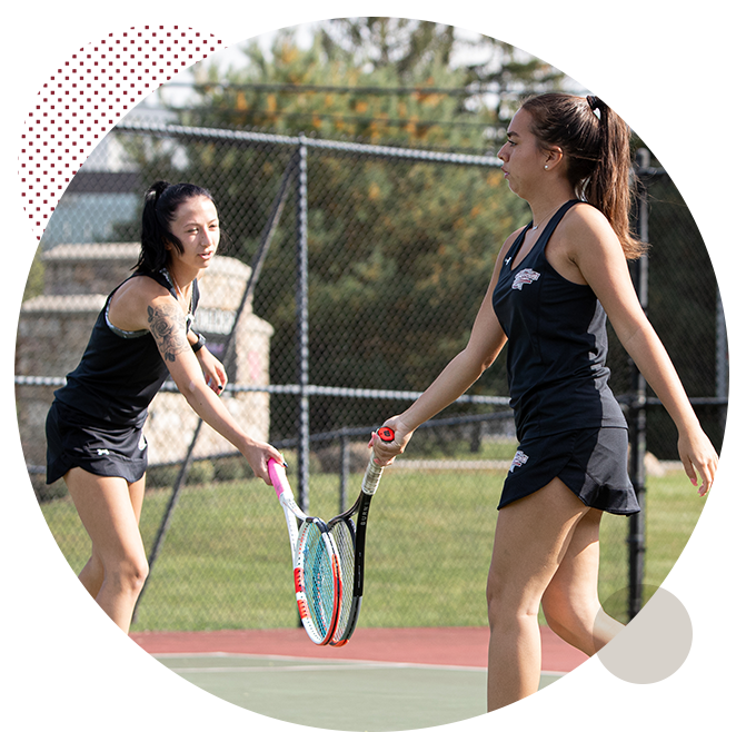 Women's tennis players touching rackets together 