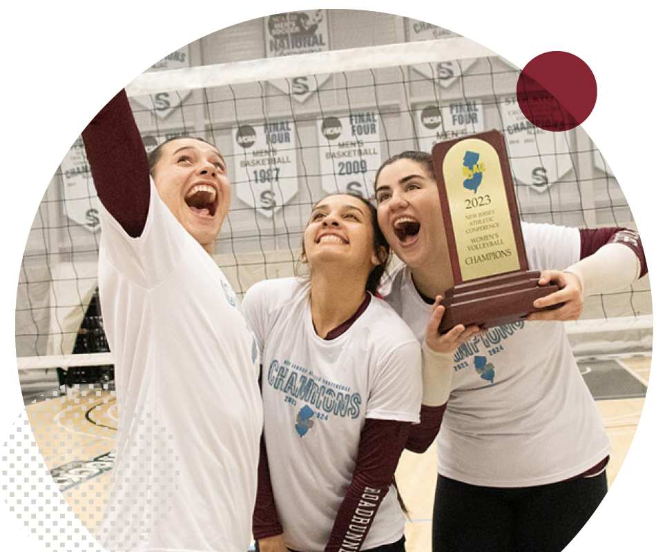 RCNJ Women's Volleyball players excitedly holding a trophy