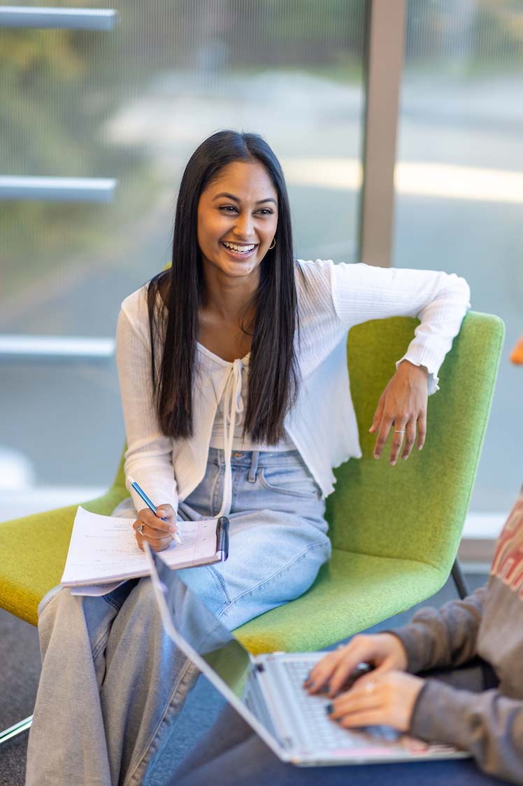 College student taking notes in the Learning Commons