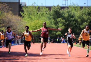 Ramapo student athlete Cheickna Traore ‘23, arms spread out running in center track lane, as he competes against 4 other college athletes.