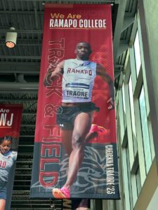 A large vertical banner of Cheickna Traore '23 running hangs from the ceiling in the Bradley Sports and Recreation Center