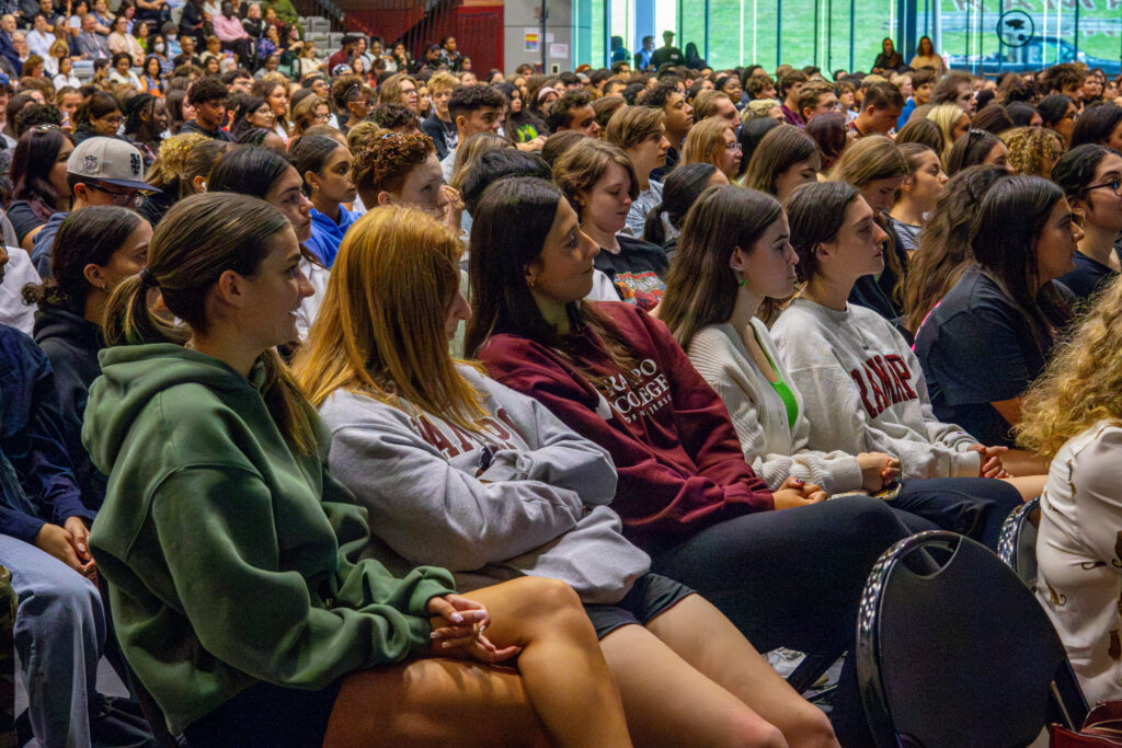 Students sit in rows, facing to the right to listen to speakers deliver addresses at the 2024 Convocation