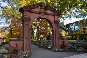 The Havemeyer Arch during fall, surrounded by colorful trees and mums along the rock walls.