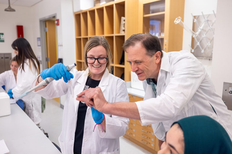 Professor checking a student's work in a chemistry lab